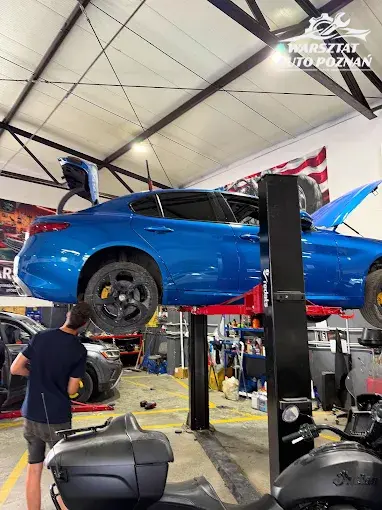 Mechanik przy Alfa Romeo na podnośniku — diagnostyka w warsztacie w Luboniu